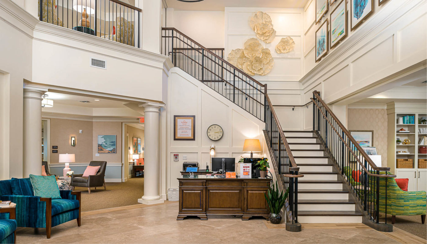 A lobby in Boynton Beach with a stairway and couches.