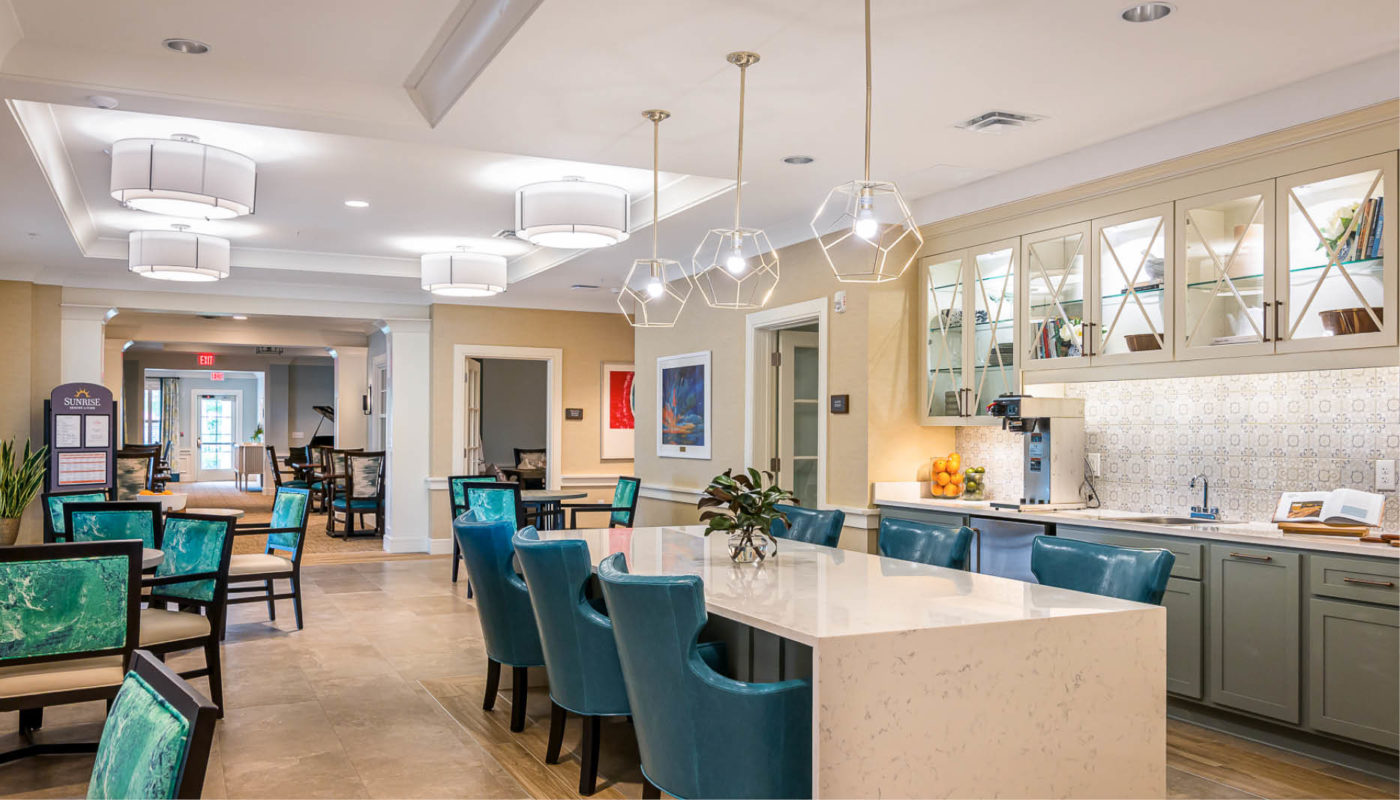 An open kitchen and dining area with blue chairs located in Boynton Beach.