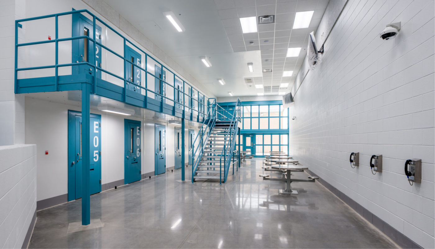 A Detention Center cell with blue walls and stairs.