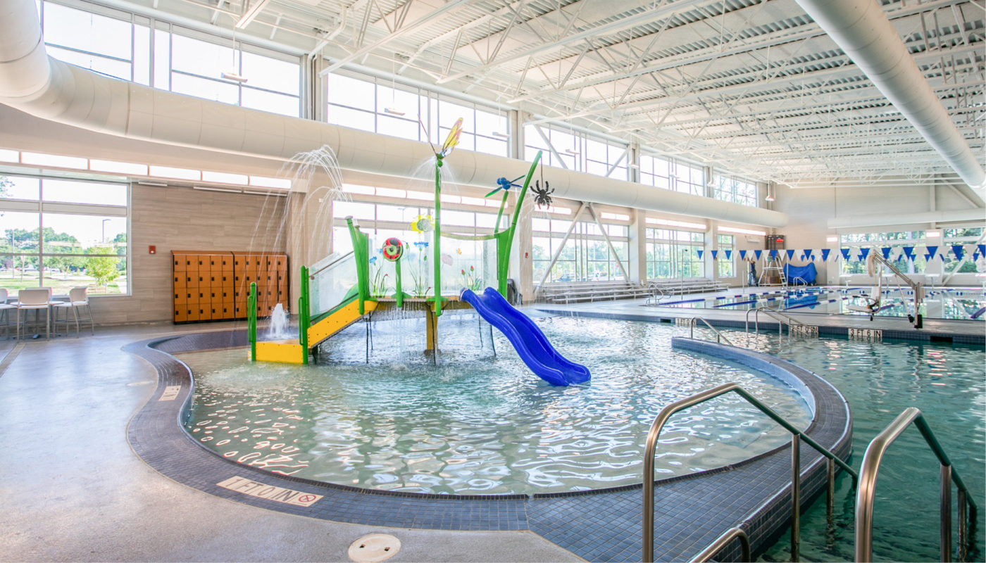 A YMCA indoor swimming pool with a slide at the Aquatic Center.