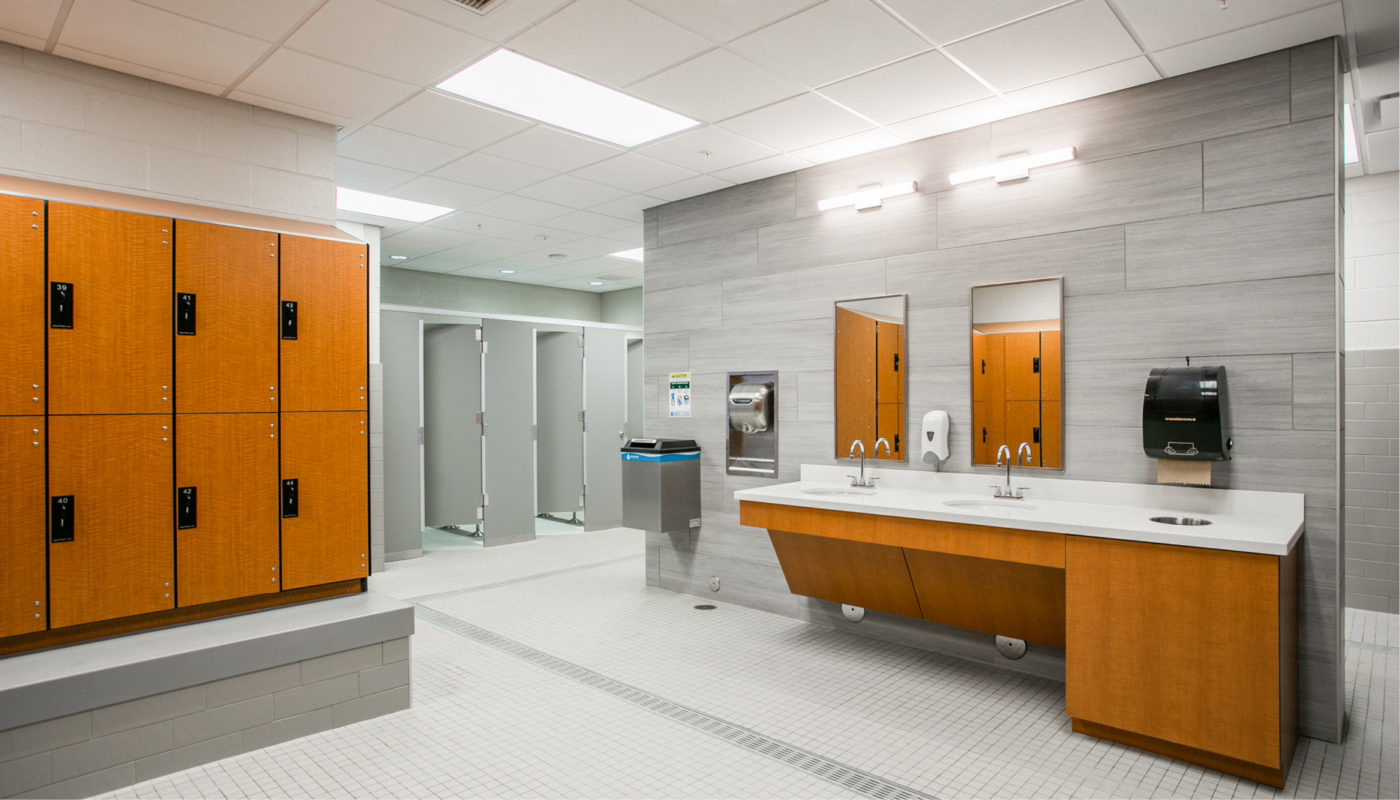 The Frank J. Thornton YMCA Aquatic Center features a bathroom with two sinks and a mirror.