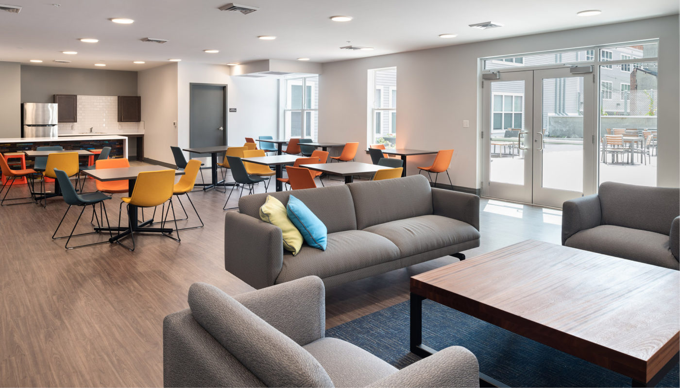 A modern living room with cozy couches, elegant tables and comfortable chairs in the Four Ten Lofts.