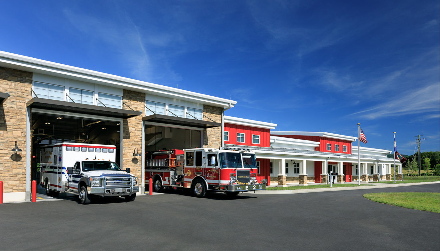 A fire truck parked in front of a fire station building.