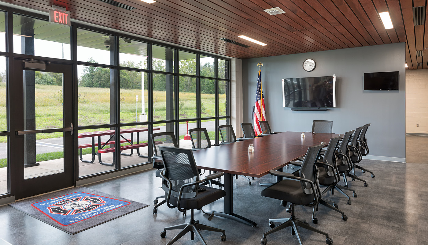 A spacious conference room with a large table and chairs.