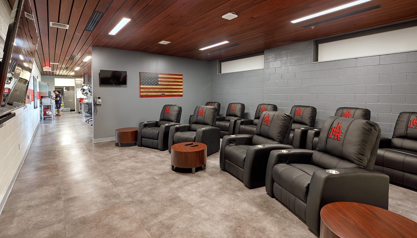 A rural room adorned with black leather recliners and an American flag.