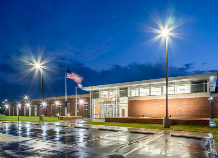 An image of the Henry County Adult Detention Center building at night with lights on.