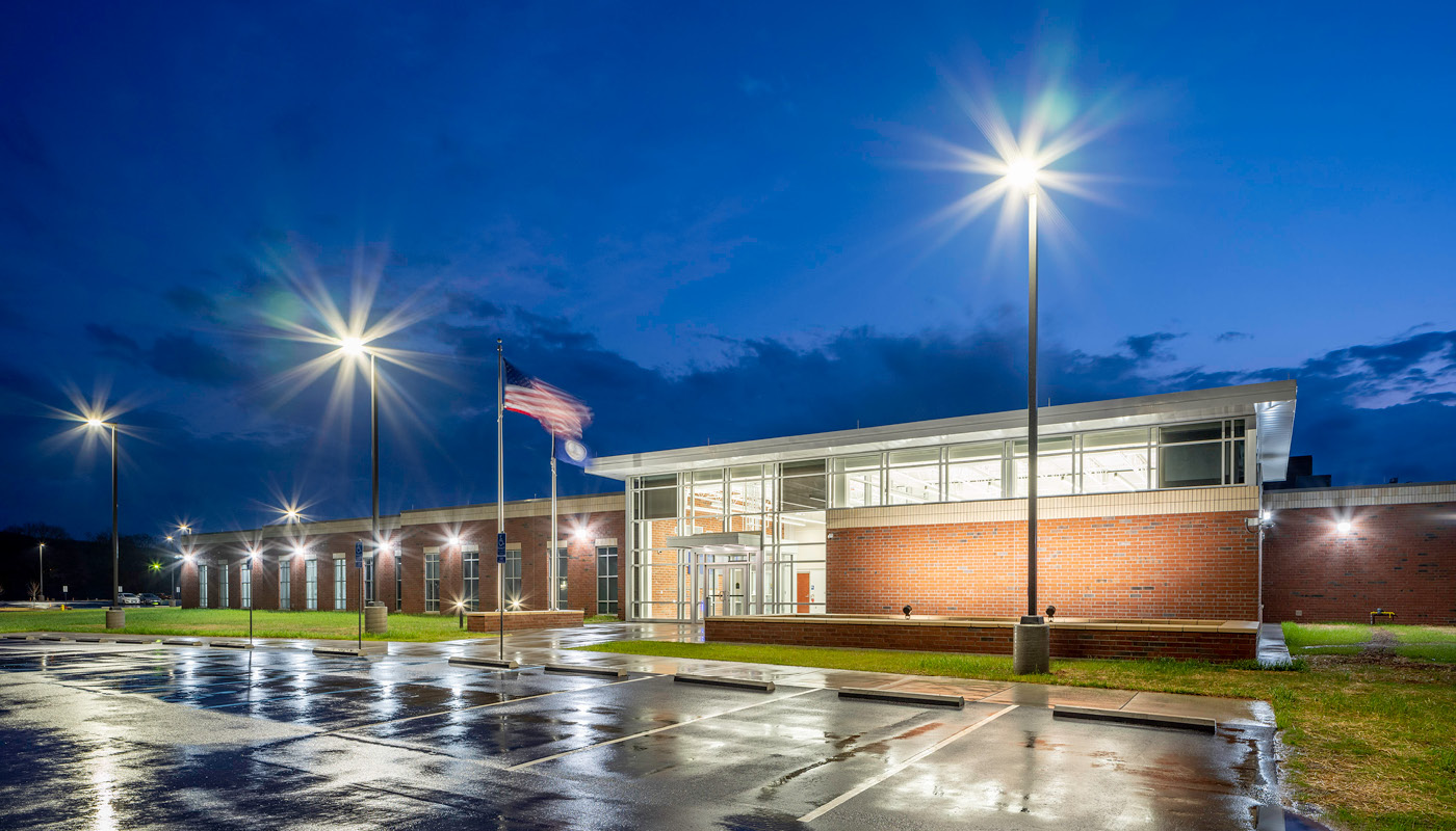 An image of the Henry County Adult Detention Center building at night with lights on.