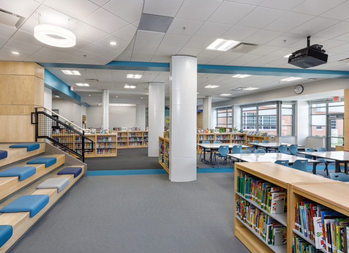 The interior of Holladay Elementary School library, with blue benches and bookshelves.