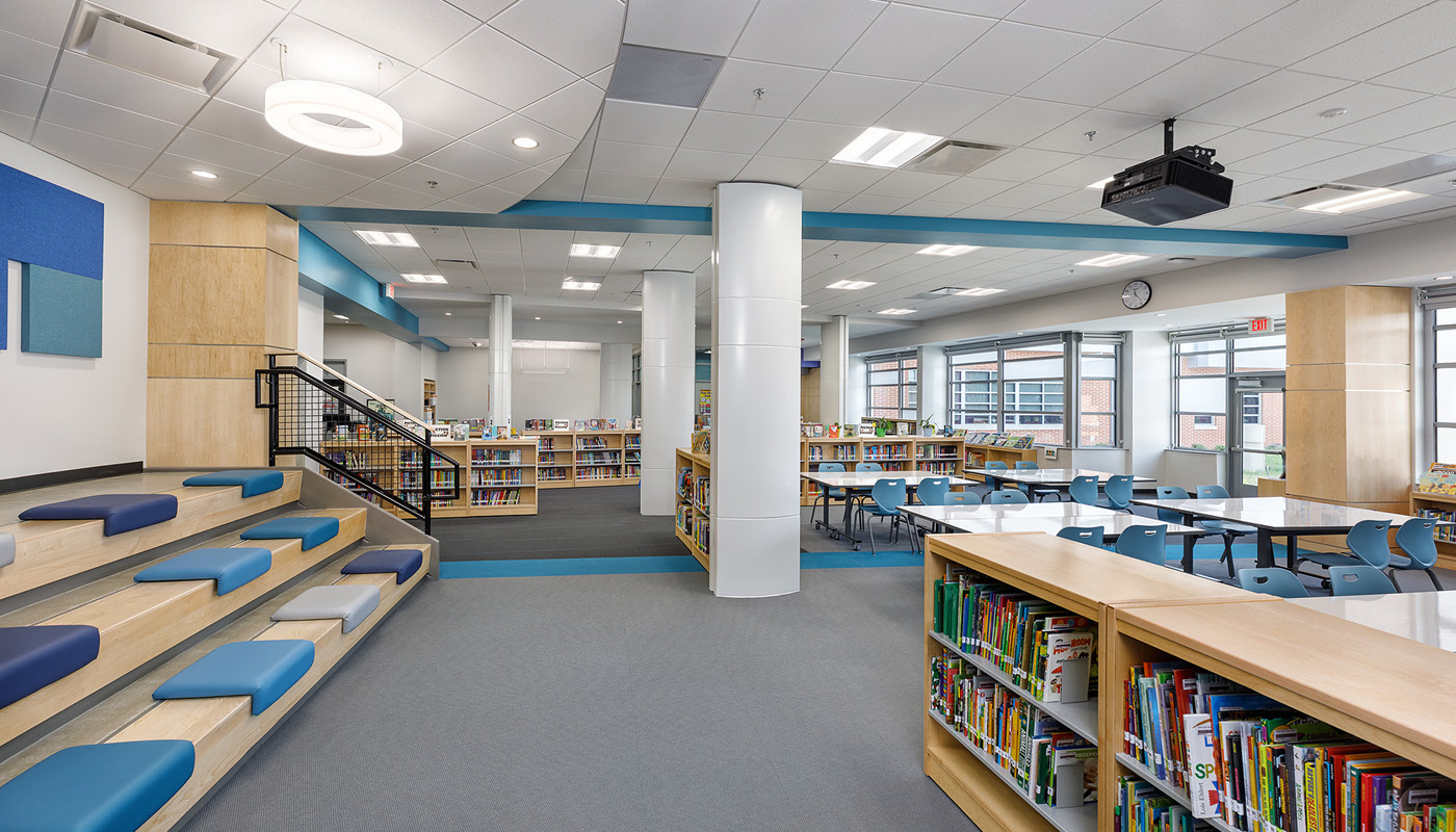 The interior of Holladay Elementary School library, with blue benches and bookshelves.