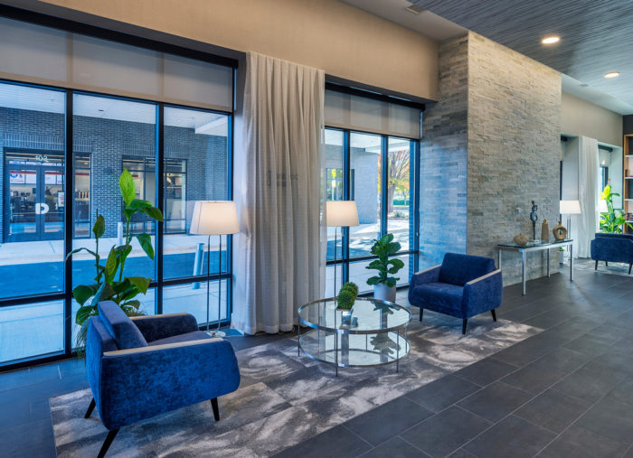 A lobby at Village Center with blue chairs and a glass wall.