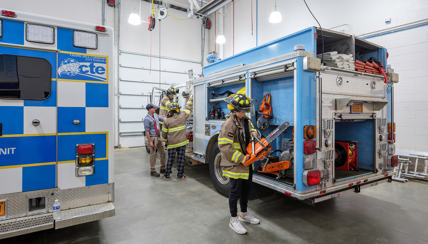 Students practice working on a fire apparatus in Chapel Hill High School, a renovated K-12 facility in North Carolina
