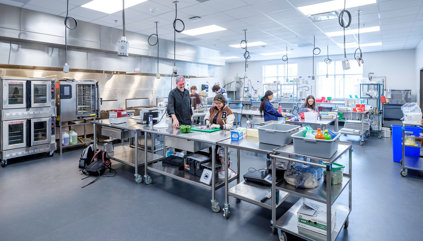 Students prepare food in a culinary arts classroom in Chapel Hill High School, a renovated K-12 facility in North Carolina