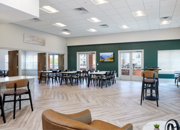 Tables and chairs grouped in a large room in renovated Atlantis Apartments, Norfolk, Virginia