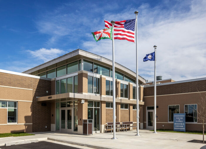 A juvenile detention center with flags flying in front of its architecture.
