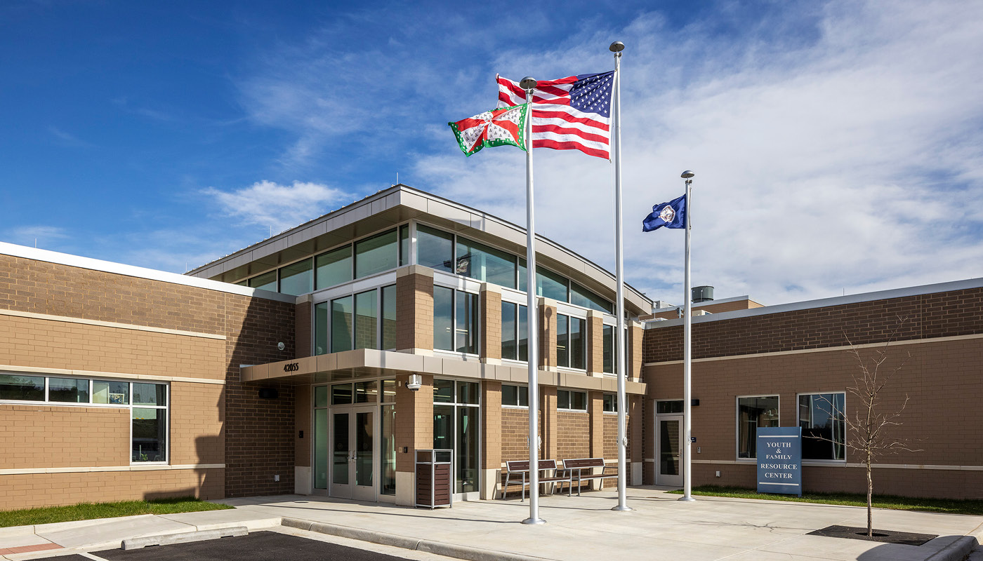 A juvenile detention center with flags flying in front of its architecture.