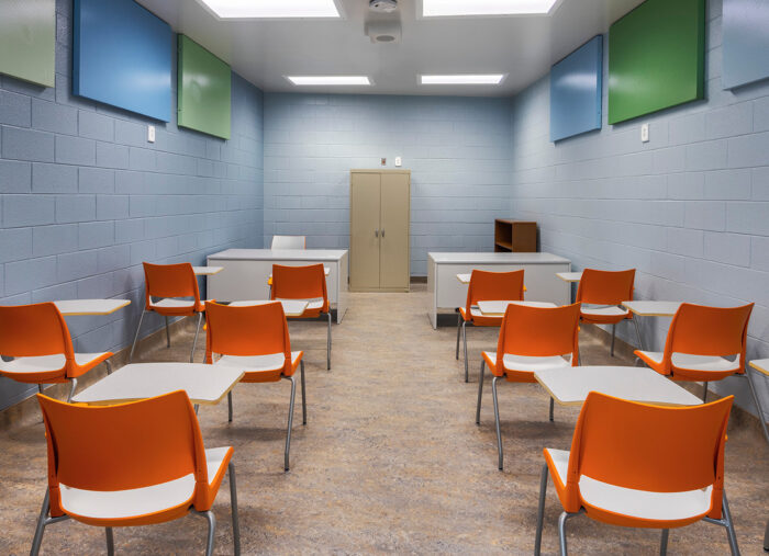 A room full of orange chairs in a juvenile detention center.