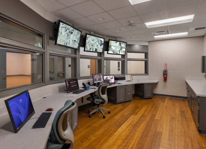 A computer room with several monitors and a desk, designed according to juvenile detention center architecture.